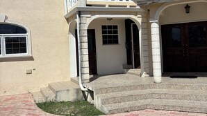 Ein zweistöckiges Haus mit Balkon, Eingangstür und Garage.