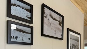 Una pared con varias fotografías blanco y negro de paisajes nevados y esquiadores.