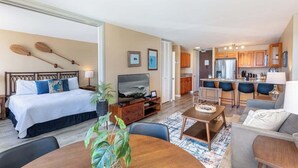 A hotel room with a bed, TV, dining table, and kitchen area. - Marina Front, Large Lanai, Near Beach (Honolulu)