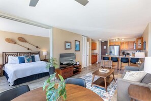 A hotel room with a bed, TV, dining table, and kitchen area. - Marina Front, Large Lanai, Near Beach (Honolulu)