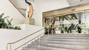 A staircase with a metal handrail leading to a modern interior space. - Cozy Waikiki Studio, Pool, Gym & BBQ (Honolulu)