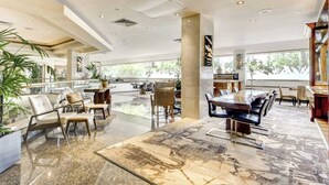 A spacious lobby with a marble floor, seating areas, and large windows offering natural light. - Cozy Waikiki Studio, Pool, Gym & BBQ (Honolulu)