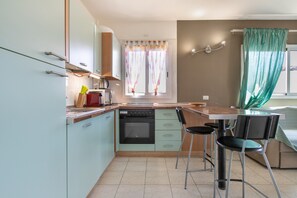 A compact kitchen with a dining area, a window with curtains, and a kitchenette. - Callao Penthouse for Holidays with Balcony and Wi-Fi (Callao Salvaje)