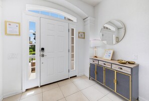A room with a white door, a mirror, a cabinet with drawers, and a tiled floor. - NEW | Free Pool Heat | Gameroom | Sunset View | Minutes from Disney (Kissimmee)