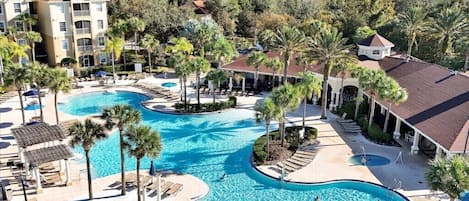 A resort with multiple swimming pools, palm trees, and a large building with balconies.