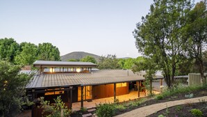 Una casa moderna con tetto piatto, ampie finestre e una zona esterna coperta.