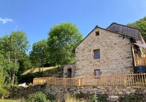 A stone building with a wooden fence, a small door, and a window. - Le Verger - VEBRON - Gîte (VEBRON)