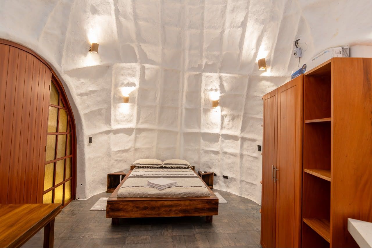 Un dormitorio con cama de madera, armario de madera y un banco empotrado.