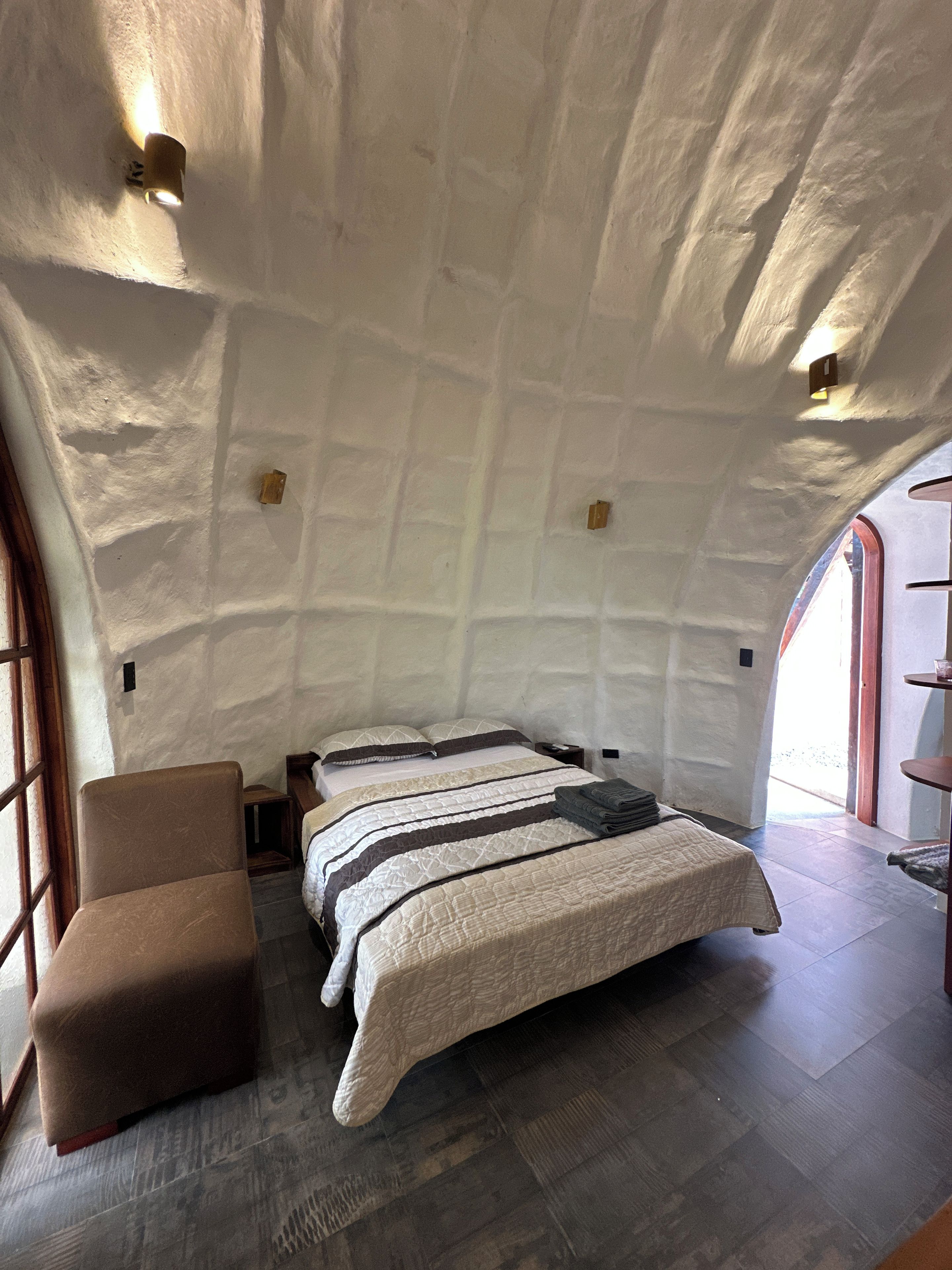 Un dormitorio acogedor con cama, una silla y ventana.