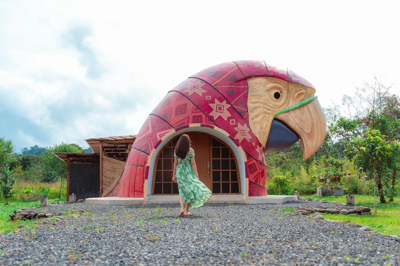 Um edifício singular com uma grande estrutura semelhante a um pássaro, uma porta de madeira e uma construção menor ao lado.