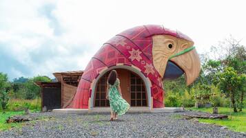 Um edifício singular com uma grande estrutura semelhante a um pássaro, uma porta de madeira e uma construção menor ao lado.