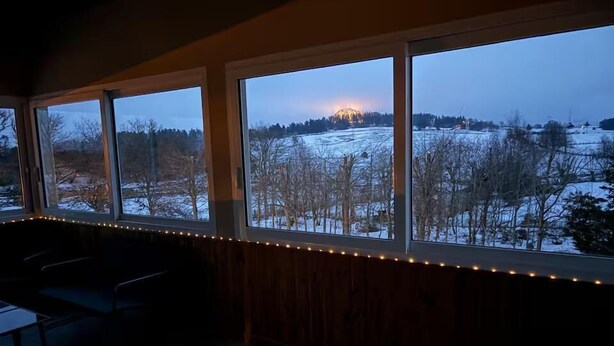 A room with large windows overlooking a snowy landscape at dusk. - Gîte du Roc 8/10 persons (SAINT-SAUVEUR-DE-PEYRE)