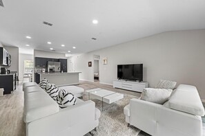 Ein modernes Wohnzimmer mit einer Couch, einem Couchtisch und einem Fernseher.