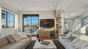Un salon moderne avec un canapé, une table basse et un téléviseur.
