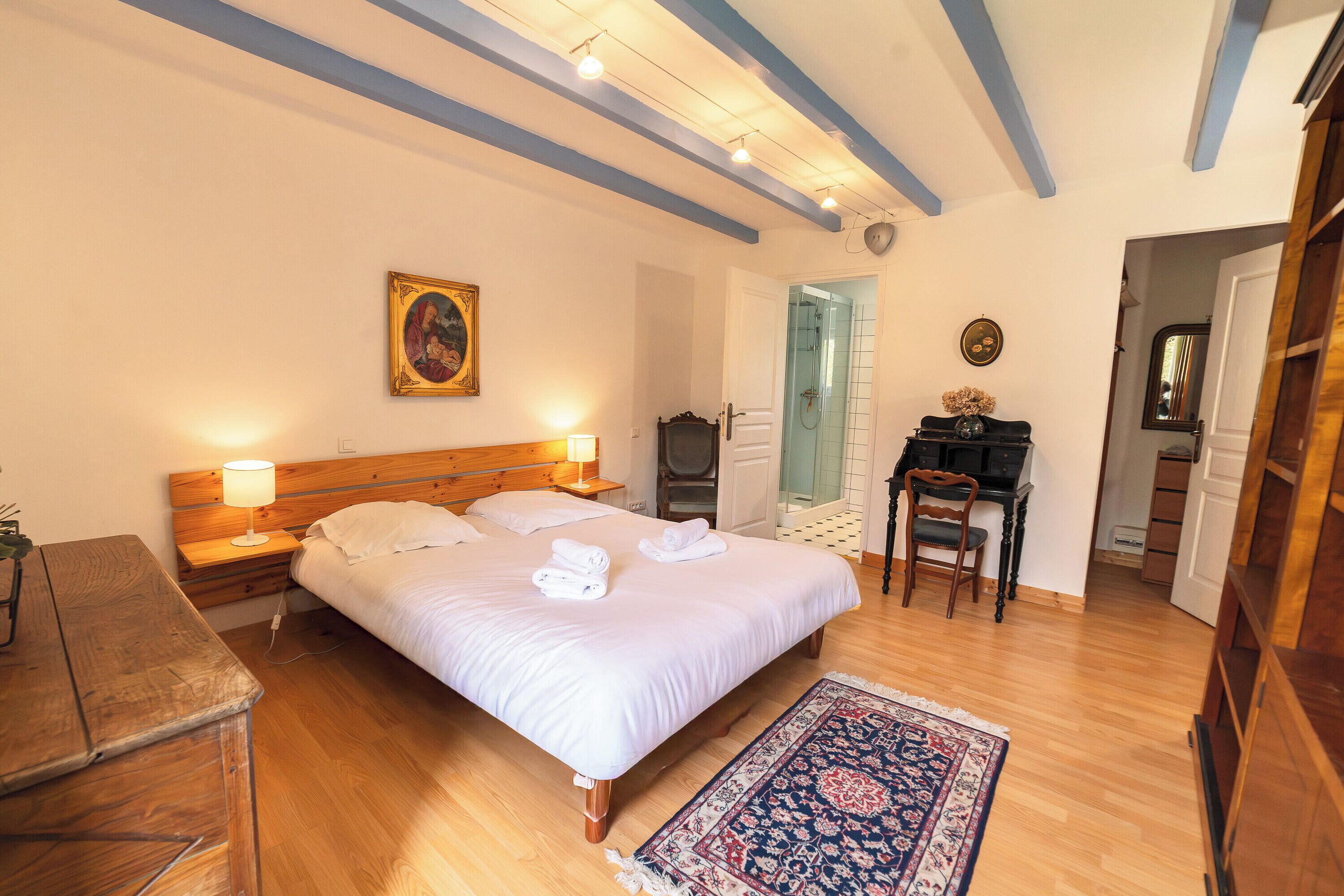 Una camera da letto con un letto, comodini, una scrivania e una sedia.