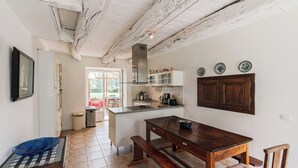 A kitchen with a wooden table, bench, and cabinets.