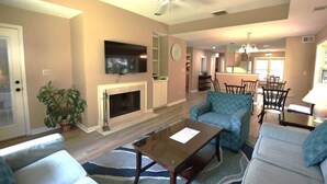 A living room with a fireplace, a television, and seating. - Shipyard Villa, Lagoons, Golf, Pool & Beach Nearby (Hilton Head Island)