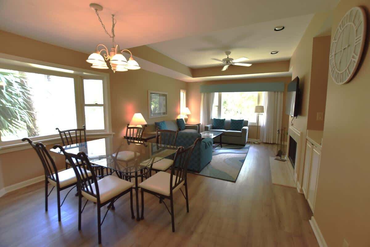 A living room with a dining table, chairs, a sofa, and a television.