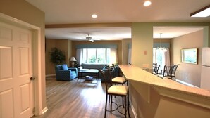 A kitchen with a bar area, a dining table with chairs, a sofa, and a ceiling fan. - Family Hilton Head Getaway, Pool, Beach Access, Sleeps 6 (Hilton Head Island)