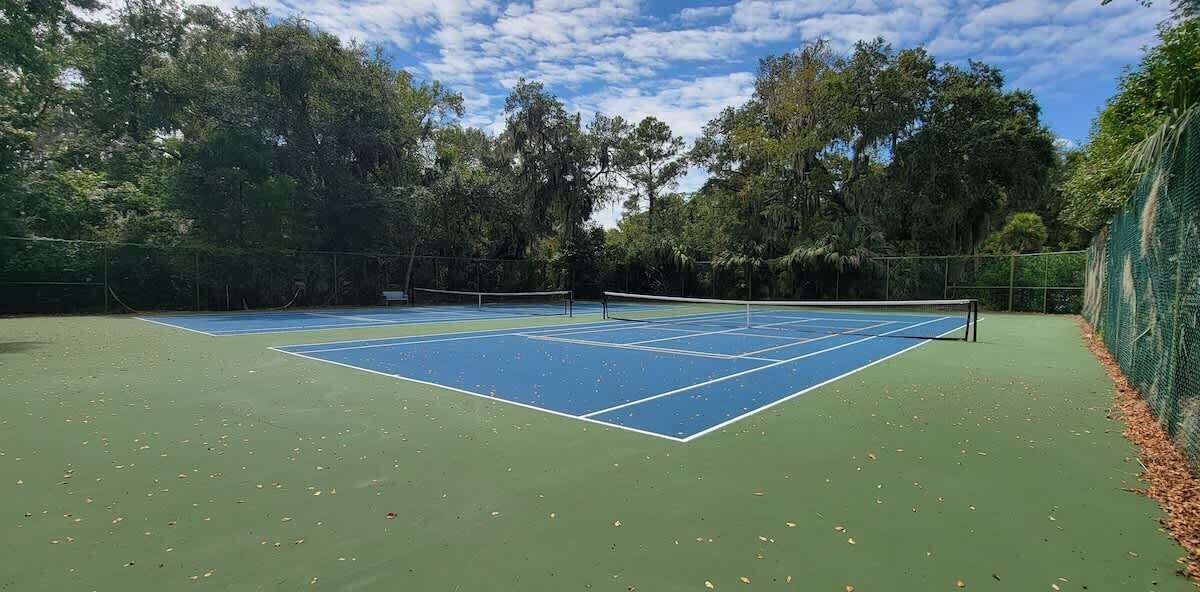 A tennis court surrounded by trees.