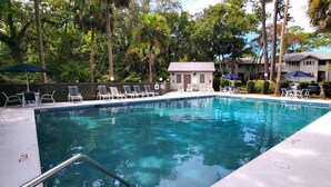 A swimming pool with lounge chairs, a small building, and surrounding trees. - Family Hilton Head Getaway, Pool, Beach Access, Sleeps 6 (Hilton Head Island)