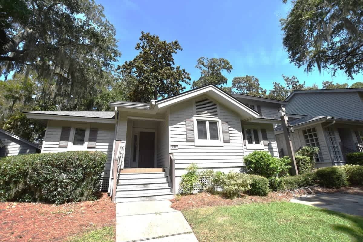 A two-story house with a front porch, a small front yard, and a driveway.