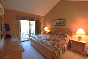 Un dormitorio con cama, dos lámparas de noche, una silla, escritorio y ventana con cortinas.