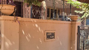 Uma parede com uma placa com o nome 'JOSEPH ILLAM' e um portão de metal.