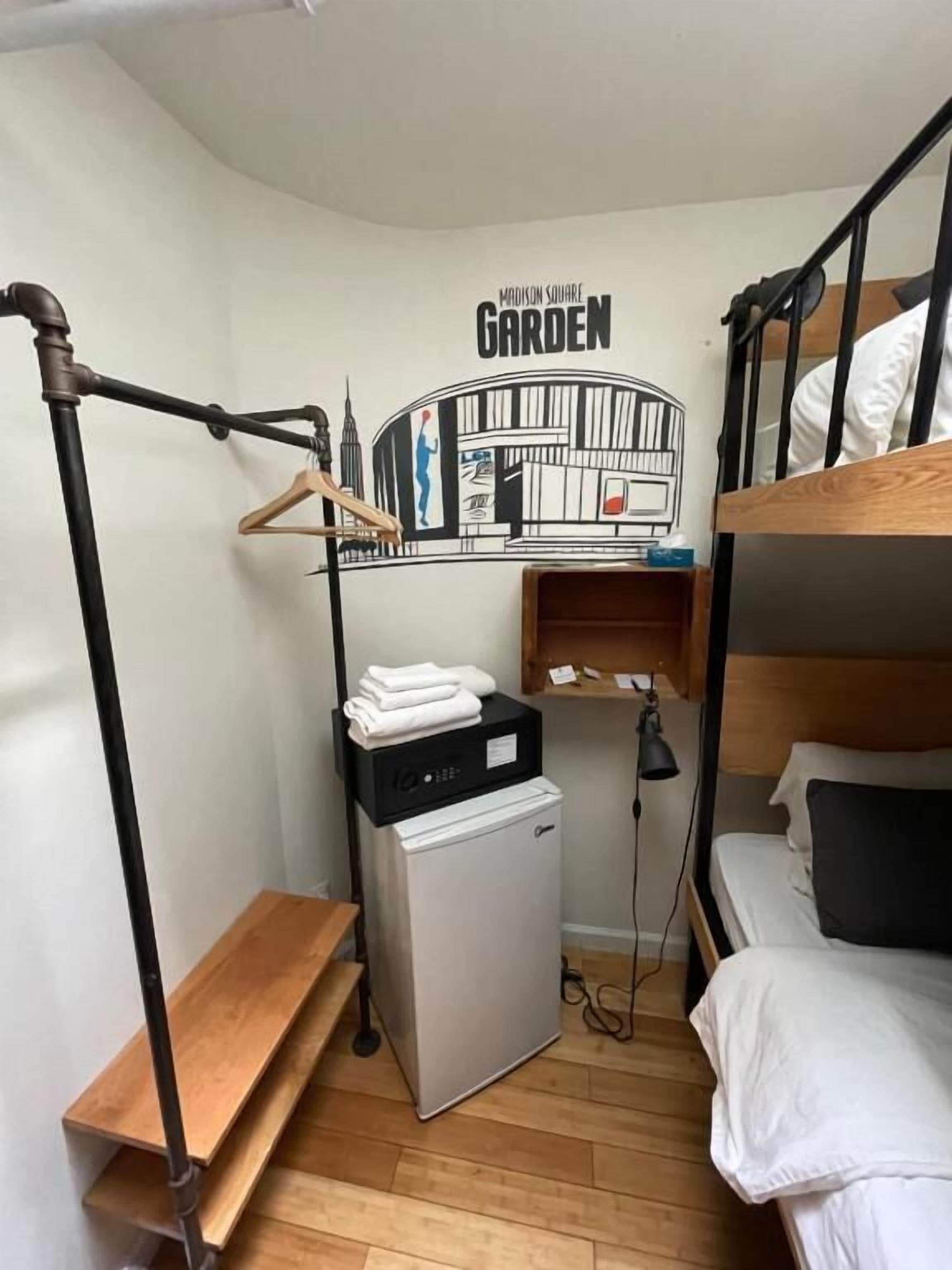 Ein kleines Zimmer mit Etagenbett, einer Waschmaschine, einem Wäscheständer und einem an der Wand befestigten Regal.