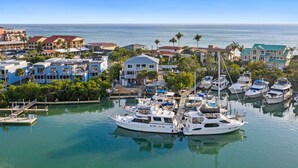 A marina with several boats docked, surrounded by residential buildings and palm trees. - Waterfront 3 Bedroom Condo with Beach Access Walkable to Everything. (Englewood)