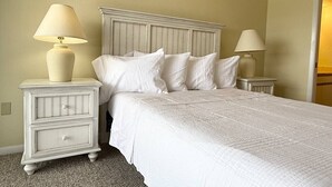 A bedroom with a bed, two nightstands with lamps, and a headboard. - Waterfront Condo w/Private Beach on Manasota Key! (Englewood)