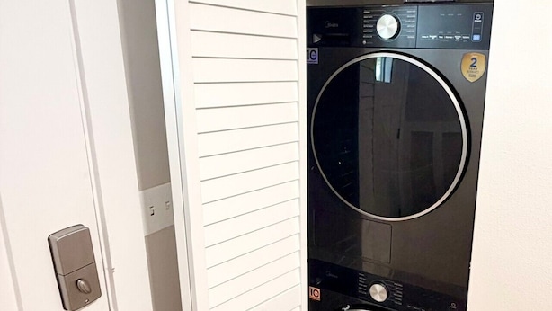 Una lavandería con una puerta, lavadora y secadora.