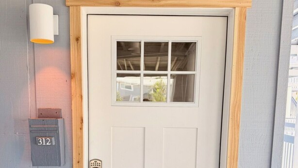 A white door with a small window, a mailbox with the number 312, and a light fixture above it. - Bayfront Condo w/Private Beach on Manasota Key - Unit 312 (Englewood)