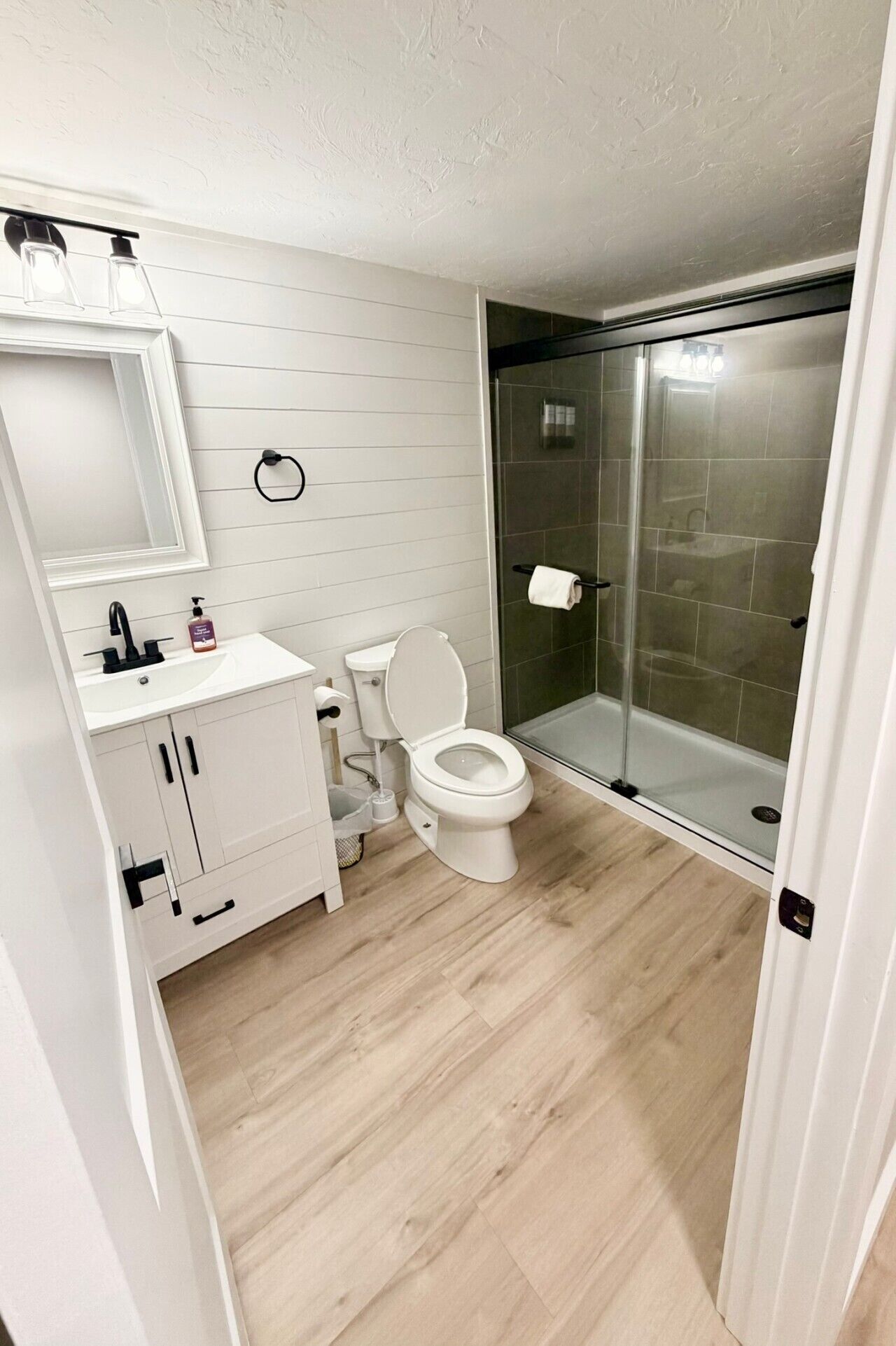A modern bathroom with a toilet, sink, and shower.