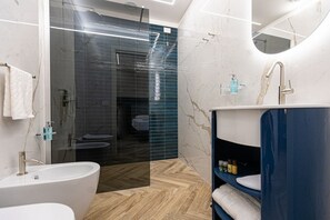 Ein modernes Badezimmer mit einer freistehenden Badewanne, einer Duschkabine und einem Waschtisch mit Spiegel.