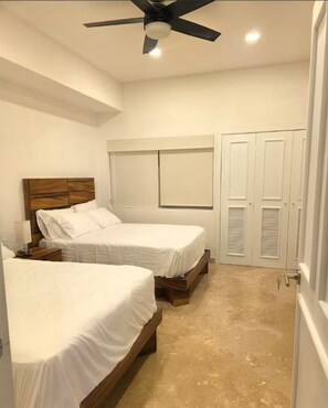 A bedroom with two beds, a ceiling fan, and a window. - Mayan Island Condominium, in Punta Diamante Acapulco Mexico (Acapulco de Juárez)