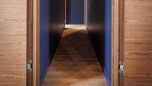 Un corridoio con rivestimenti in legno, una lampada a soffitto e quadri appesi alle pareti.