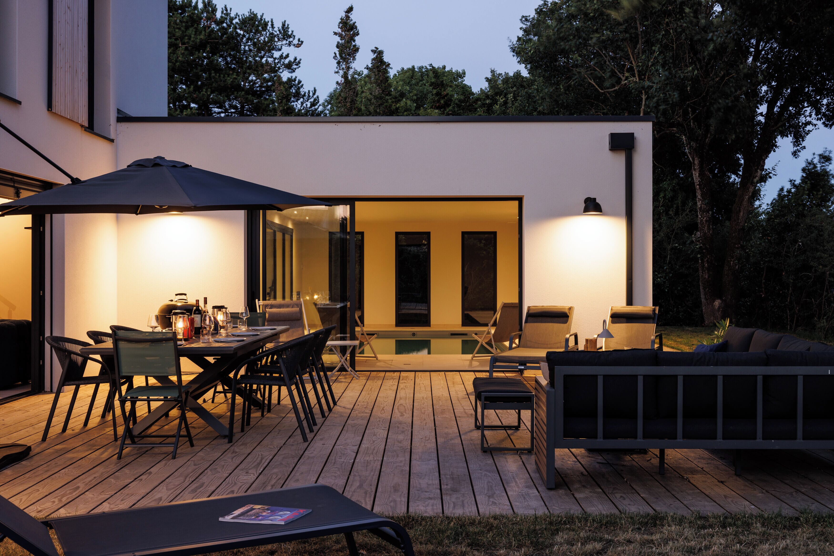 Eine Terrassengrundstück mit Essbereich, Liegestühlen und einem Pool.