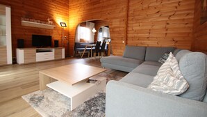 Et moderne hytteinteriør med opholdsstue, spiseområde og køkken.
