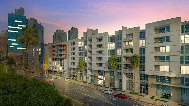 A multi-story building with a modern architectural design, featuring balconies and large windows.