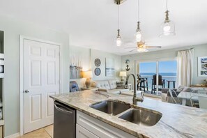 A modern kitchen with a double sink, a dishwasher, and pendant lighting. - Gulf front beautiful beachfront great view large balcony 2 king beds Royal Palms (Gulf Shores)