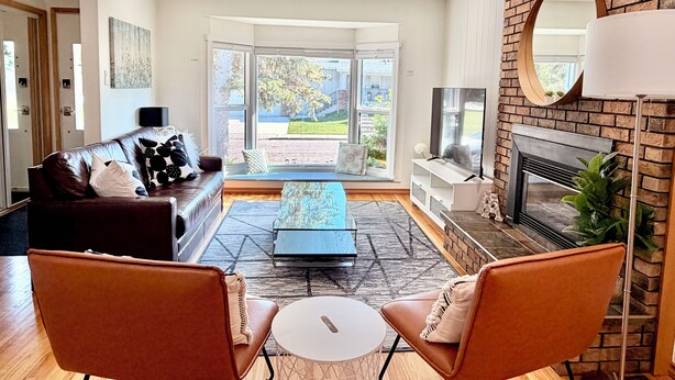 Een moderne woonkamer met een leren bank, een salontafel en twee fauteuils.