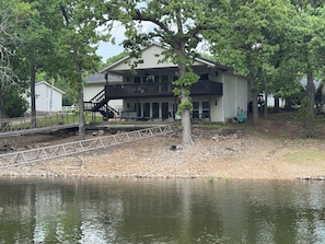 A house with a balcony, a dock, and a pond. - Duck Creek-Boat Ramp-Dock-3 king Bed-3 full bath (Afton)