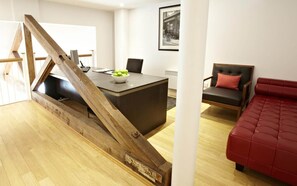 A modern living room with a wooden staircase, a dining area with a table and chairs, and a red sofa. - 2 Bedroom Apartment in Liverpool Street (London)
