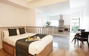 A hotel room with a bed, breakfast tray, kitchenette, dining area, and a view of the outside. - 2 Bedroom Apartment in Liverpool Street (London)
