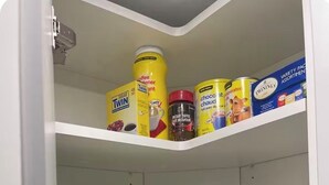 Een keuken met een koffiezetapparaat, een broodrooster en diverse koffieproducten in de planken.