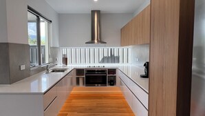 Une cuisine moderne dotée d’un îlot central, d’un four encastré et d’appareils électroménagers en acier inoxydable.
