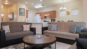 A modern living room with two sofas, a coffee table, and a kitchen in the background. - Amazing 3 King Beds  BackYard  FireTV  Spacious (Austin)