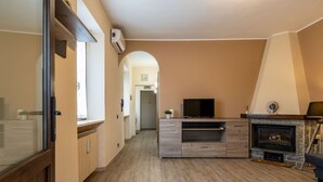 Een moderne keuken met een ingebouwde televisie, een open haard en een gang naar een andere kamer.