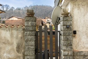 A gated entrance with stone pillars and a metal gate.